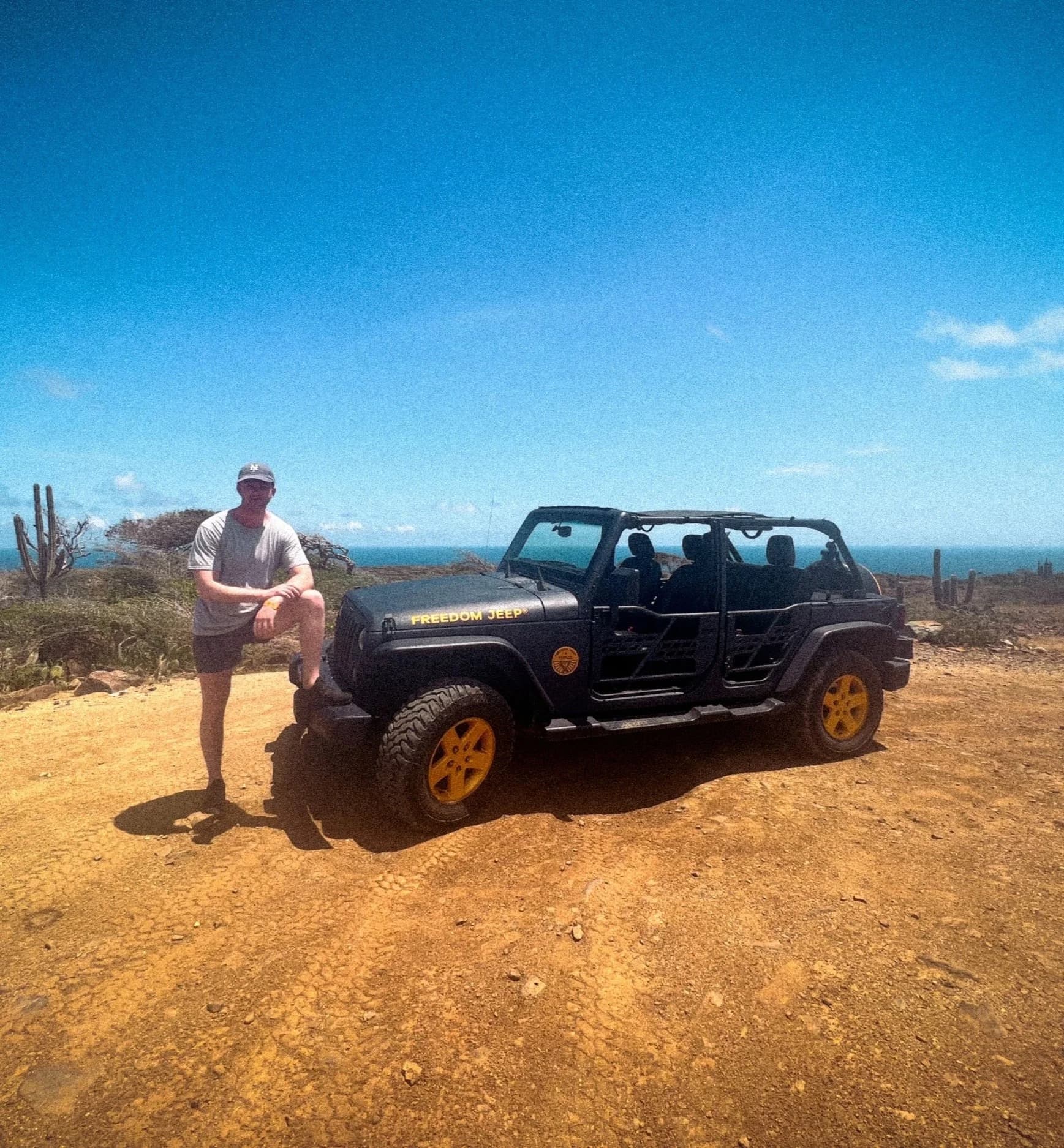 Alan Pierson standing beside a black Jeep in warm weather